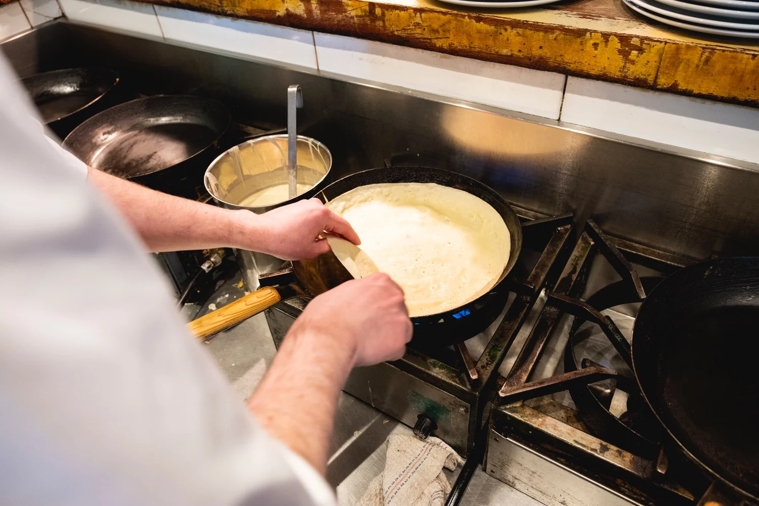 Handen gieten vers beslag in een hete pan