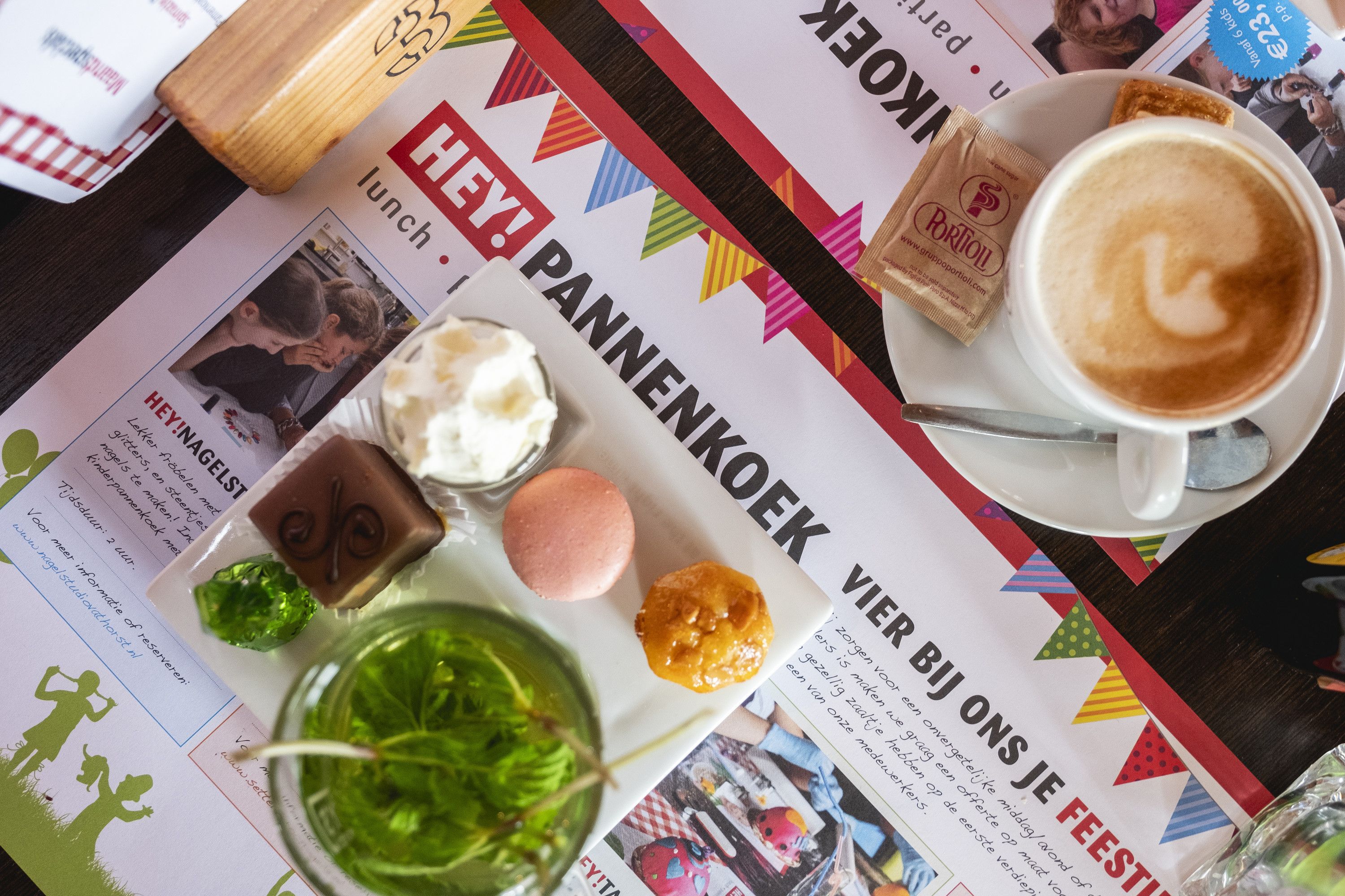 Cappuccino, verse muntthee en zoete lekkernijen op de HEY!-placemat
