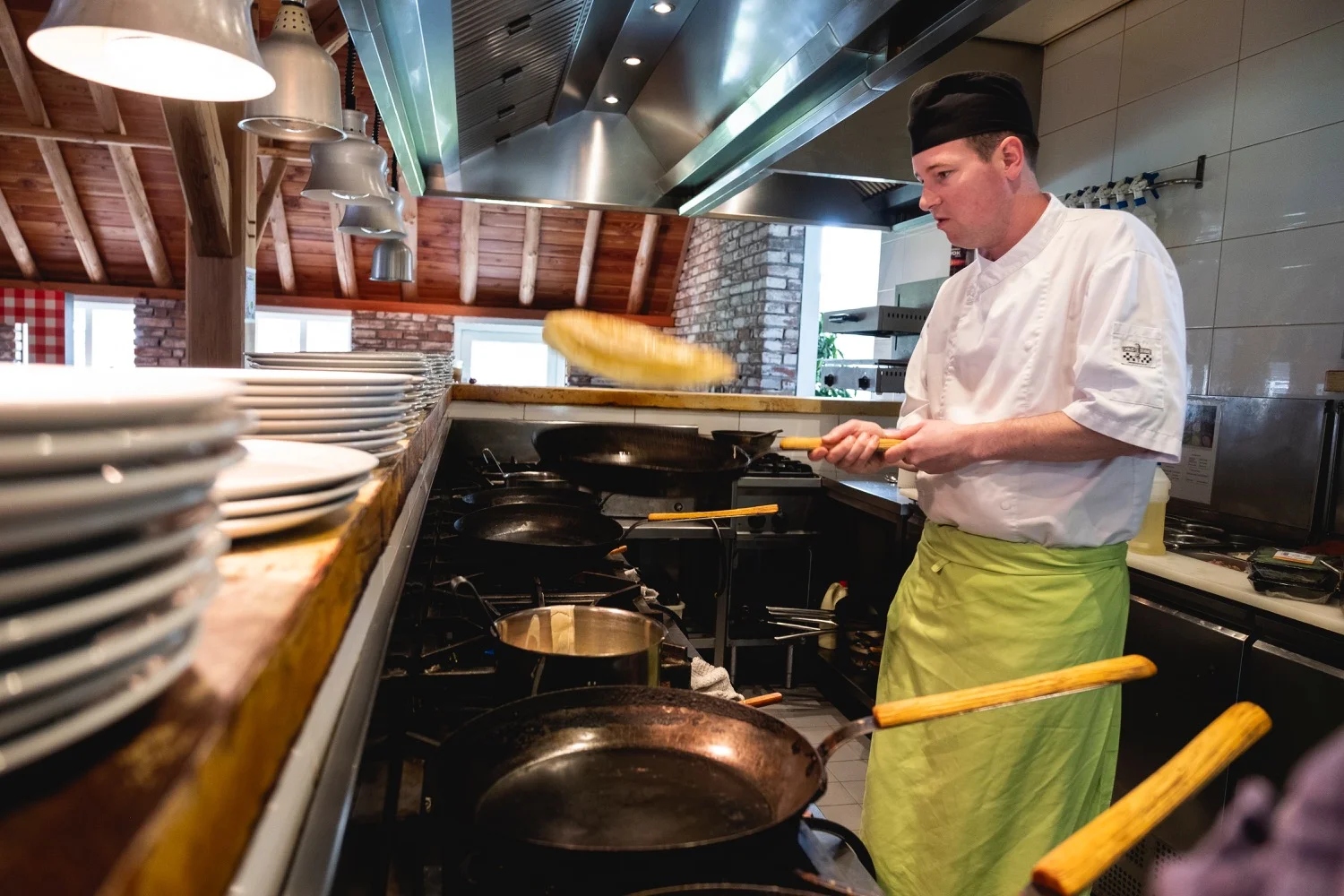Kok bakt pannenkoeken aan de pannen in de open keuken van HEY!Pannenkoek