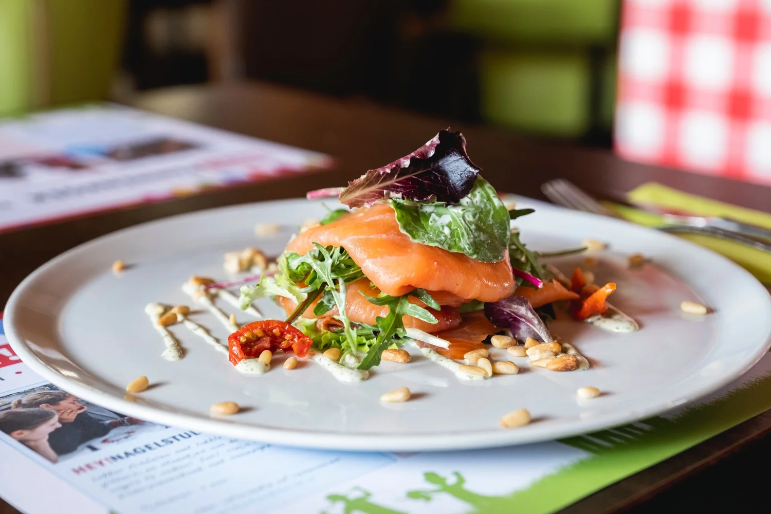 Voorgerecht met ambachtelijk gerookte zalm en gemengde sla op een wit bord