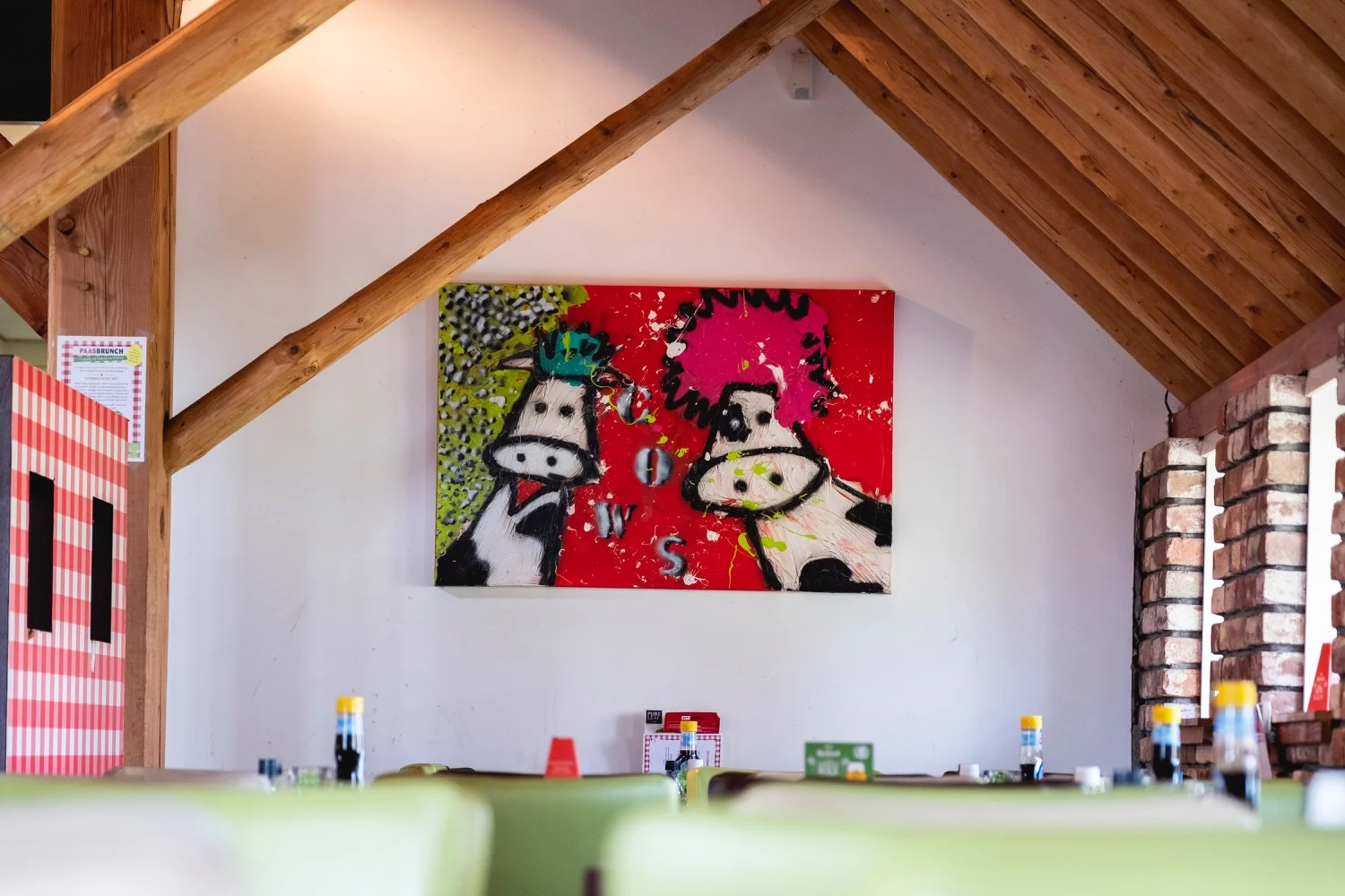 Wand in de zaal met een kleurrijk schilderij van twee koeien